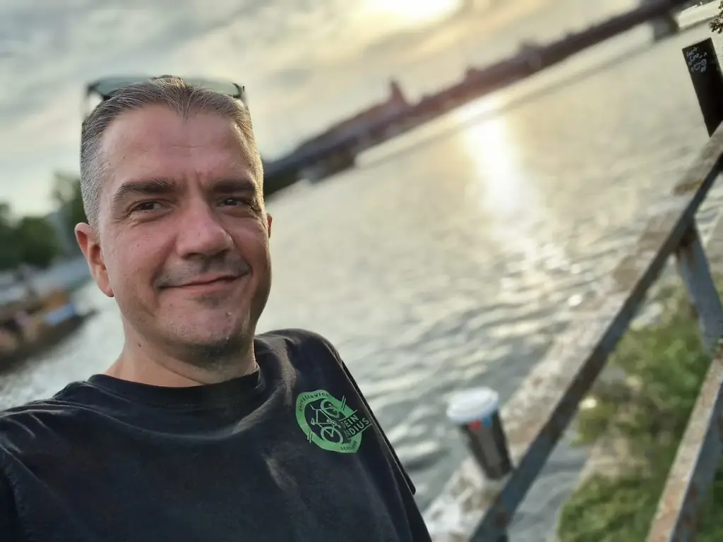 Basti, Fahrradprofi und Werkstatt-Techniker bei Dein Radius, im Dein-Radius-Shirt am Wasser